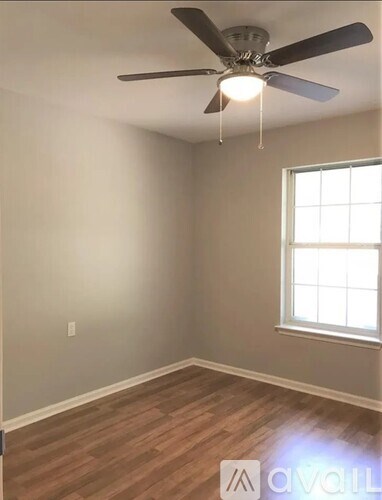 A room with a ceiling fan and a window.