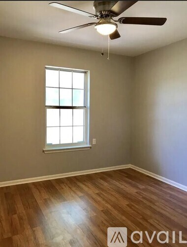 A room with a ceiling fan and a window.