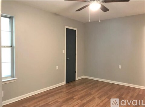 A room with a ceiling fan and a door.
