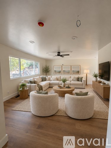 A living room with a white couch, a rug, and a ceiling fan.