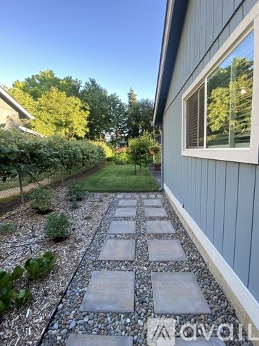 A stone pathway leads through a garden.
