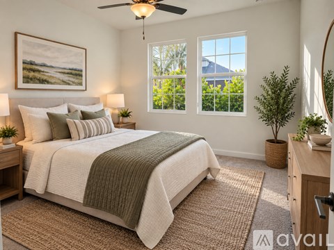 A bedroom with a large bed and a view of the outdoors through the window.