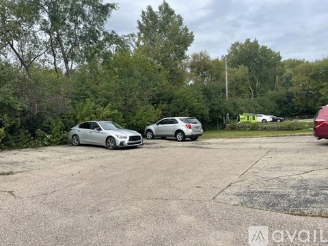 A grey car is parked in a lot with other cars.