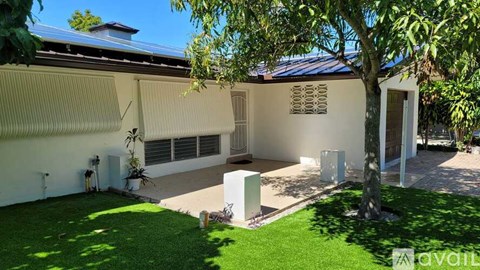A house with a white exterior and a tree in the front yard.
