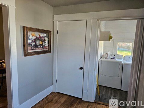 A room with a white door and a framed picture on the wall.