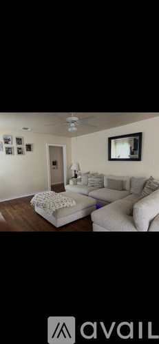 A living room with a couch and a fan.