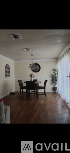 A dining room with a wooden table and chairs.