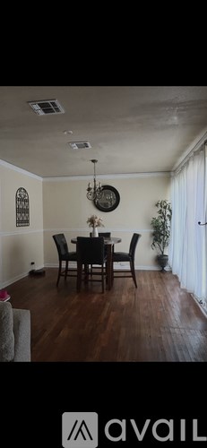 A dining room with a wooden table and chairs.