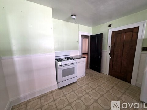 A kitchen with a white stove and a black cabinet.