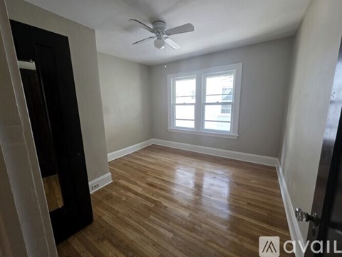 A room with wooden flooring and a ceiling fan.