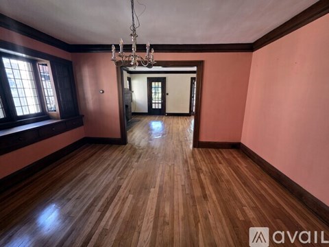 A room with wooden floors and a chandelier.