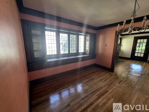 A room with wooden floors and a chandelier.