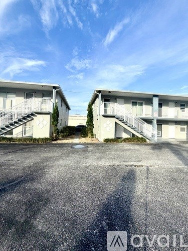 A parking lot with two buildings and a clear sky.