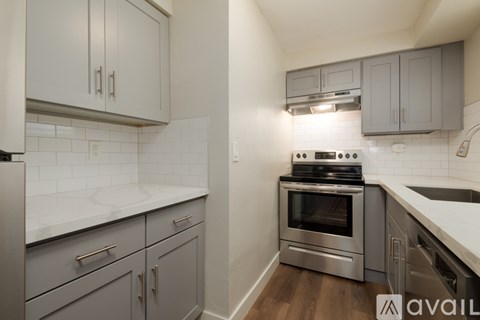 A kitchen with a stove top oven and a refrigerator.