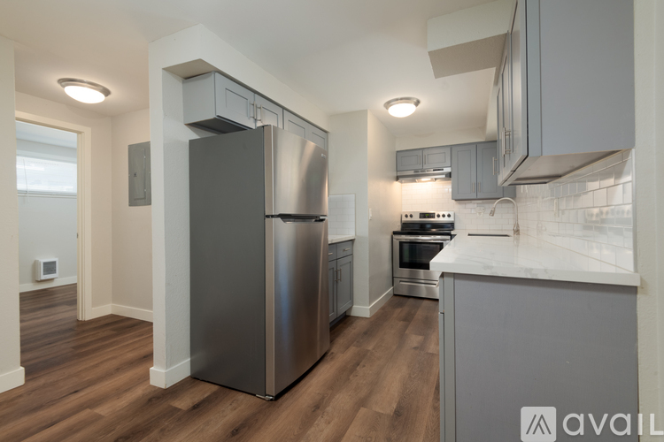 A modern kitchen with stainless steel appliances and wooden floors.