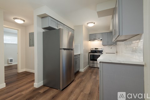 A modern kitchen with stainless steel appliances and wooden floors.