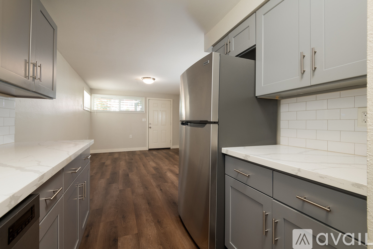 A kitchen with wooden floors and stainless steel appliances.