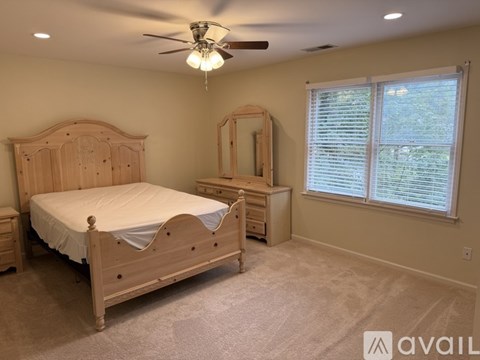 A bedroom with a bed, dresser, and mirror.
