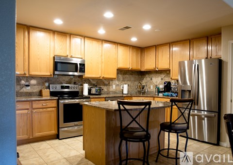 A kitchen with wooden cabinets and a granite countertop.