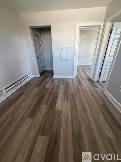 A room with wooden flooring and white walls.