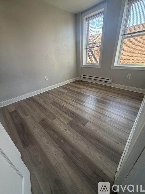 A room with wooden flooring and a window.