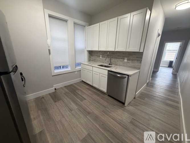 A kitchen with white cabinets and a grey countertop.
