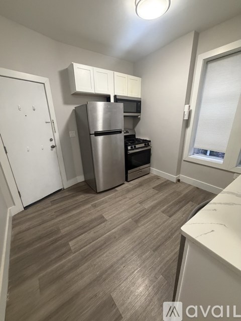 A kitchen with a stainless steel refrigerator and microwave.