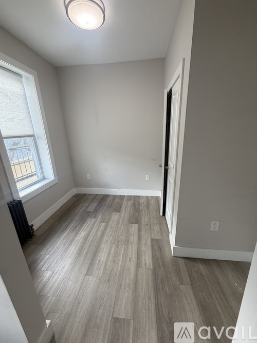 A room with a window and a radiator on the wall.