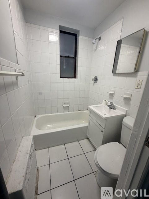 A white bathroom with a toilet, sink, and bathtub.