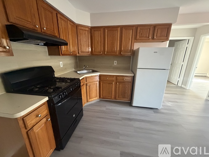 A kitchen with wooden cabinets and a black stove top oven.