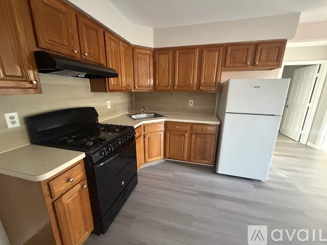 A kitchen with wooden cabinets and a black stove top oven.
