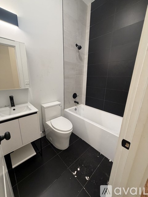 A bathroom with a toilet, sink, and bathtub.
