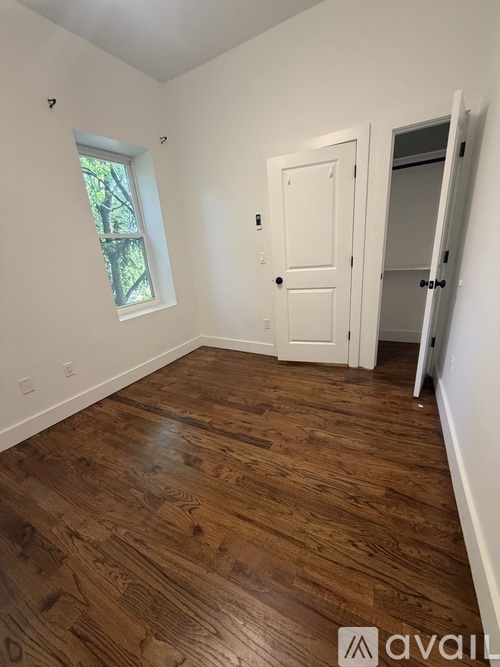 A room with wooden flooring and a white door.