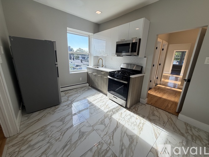A kitchen with a marble floor and a refrigerator.