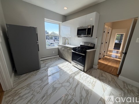 A kitchen with a marble floor and a refrigerator.