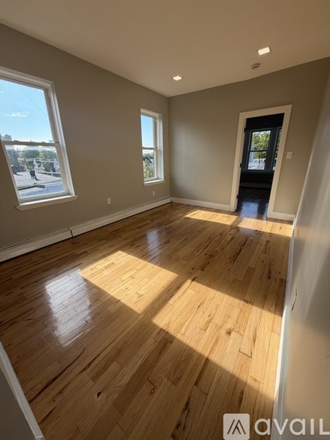 A room with wooden flooring and a large window.