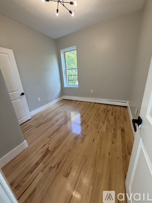 A room with wooden flooring and a window.