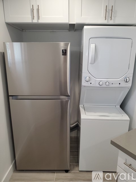 A stainless steel refrigerator and a white oven in a kitchen.