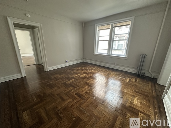 A room with wooden flooring and a window.
