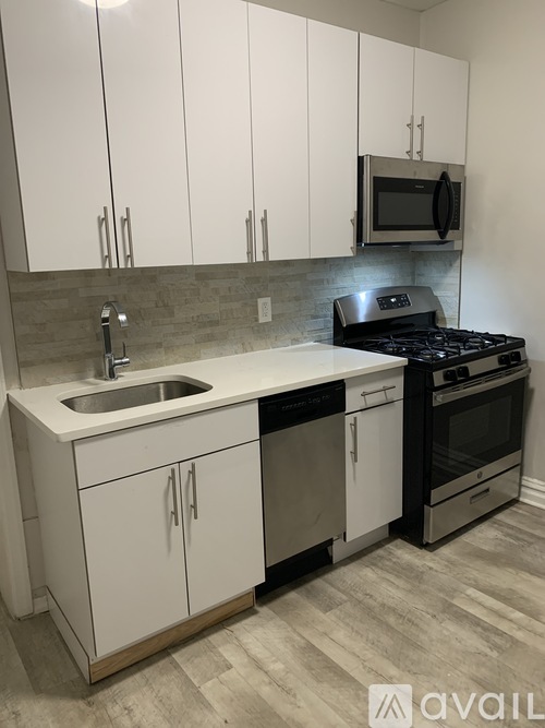 A kitchen with white cabinets and a black stove top oven.