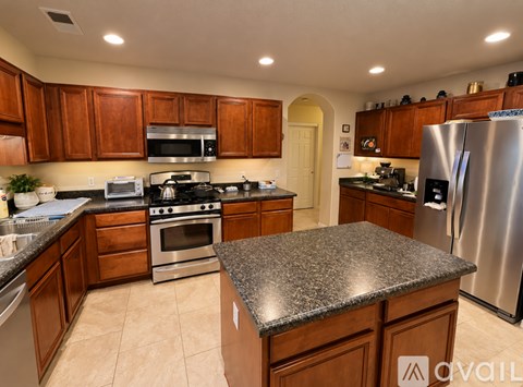 A kitchen with wooden cabinets and granite countertops.