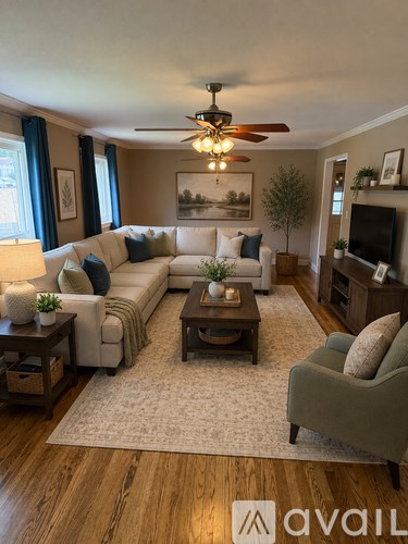 A living room with a white couch, a green armchair, and a coffee table.