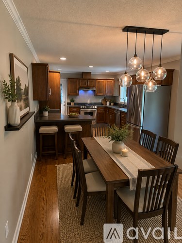 A dining room with a wooden table and chairs.