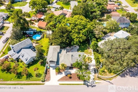 A bird's eye view of a neighborhood with houses and a pool.