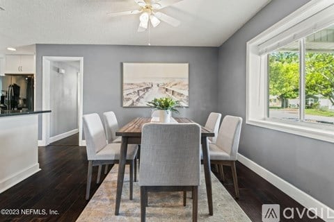 A dining room with a wooden table and chairs.