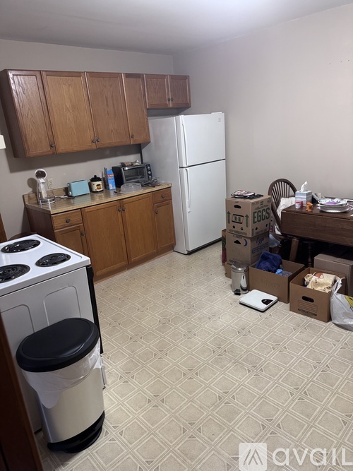 A kitchen with a white fridge and a white stove with a black lid.