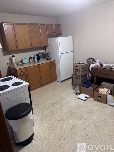 A kitchen with a white fridge and a white stove with a black lid.