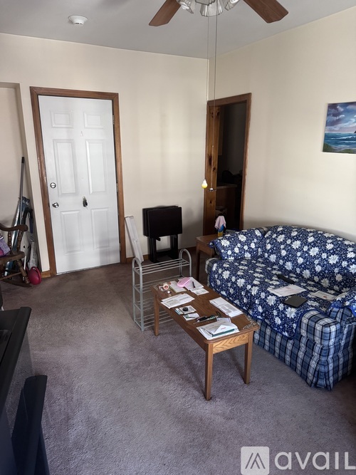 A living room with a couch, a coffee table, and a ceiling fan.