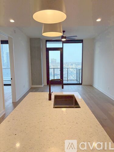 A spacious room with a marble floor and a ceiling fan.