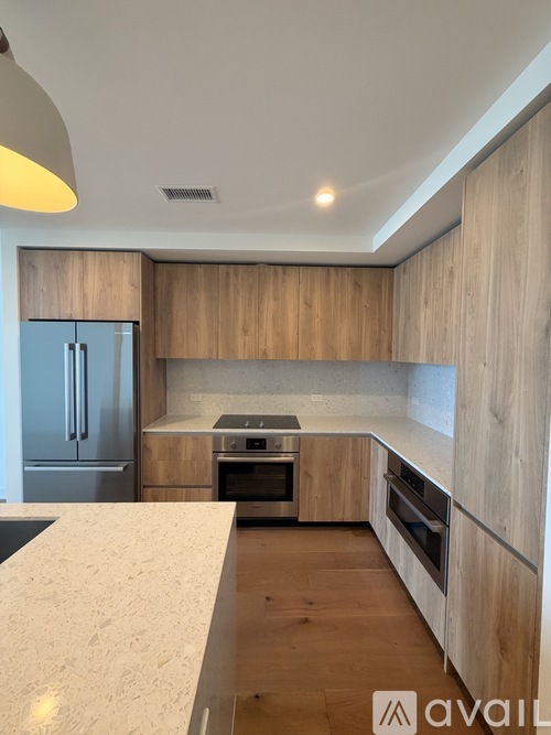 A modern kitchen with wooden cabinets and a marble countertop.